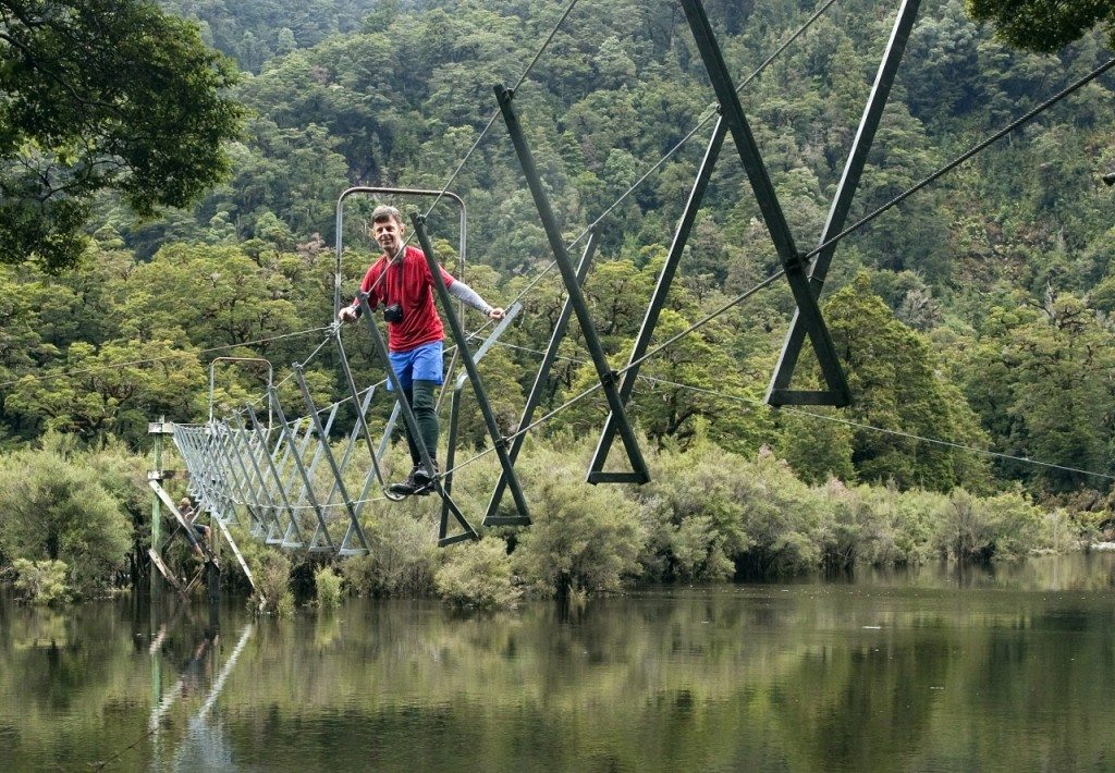 Malcolm tiptoes along the three wire bridge over the swollen Seaforth River. Photo: Ray Salisbury