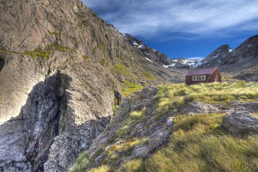 The diminutive Waimakariri Falls Hut has sheltered climbers since 1960; Waimakariri Col is at the head of this valley. Photo:  RAY SALISBURY / LIGHTHOUSE CREATIVE 